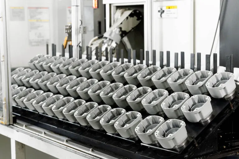 In-line automated loading system for aluminum die cast housings undergoing secondary CNC machining processes.