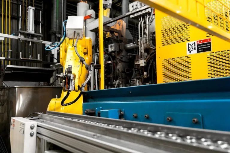 High-pressure aluminum die casting station featuring a Fanuc robotic arm for automated extraction and consistent cycle timing.