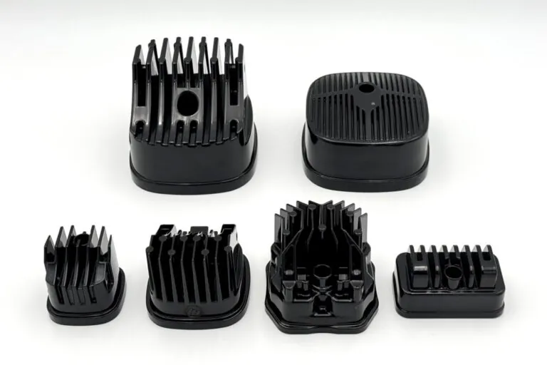 A collection of high-emissivity black liquid-coated and powder-coated aluminum thermal components illustrating diverse surface treatment options.