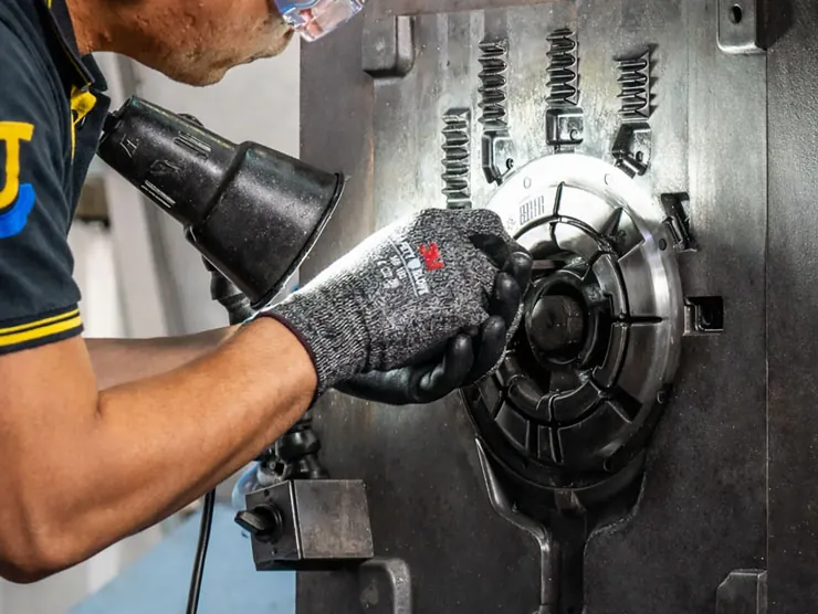 Expert JoinCast technician performing precision maintenance and manual adjustment on a high-pressure aluminum die casting mold.